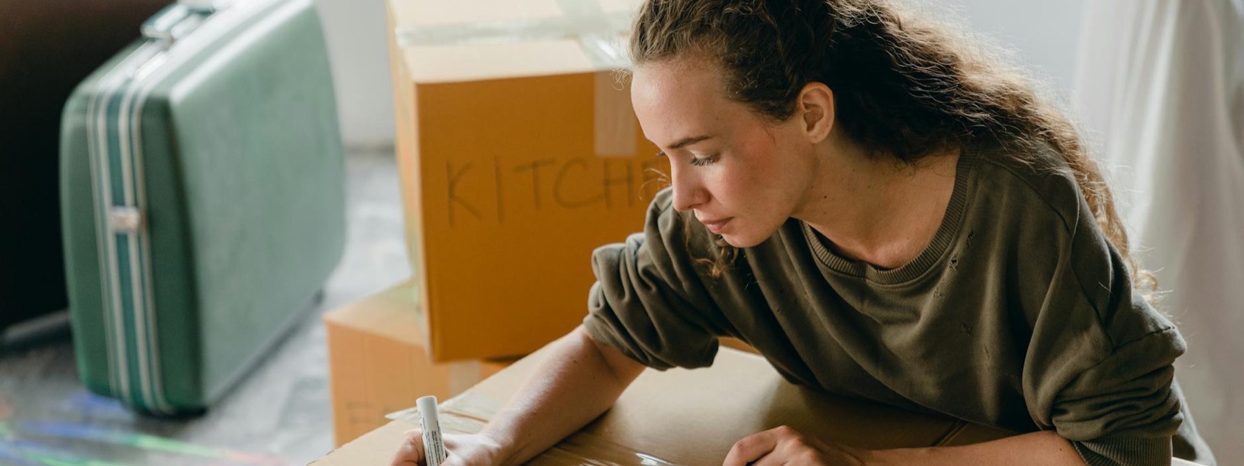 Smiling traveler moving into a bright apartment with boxes
