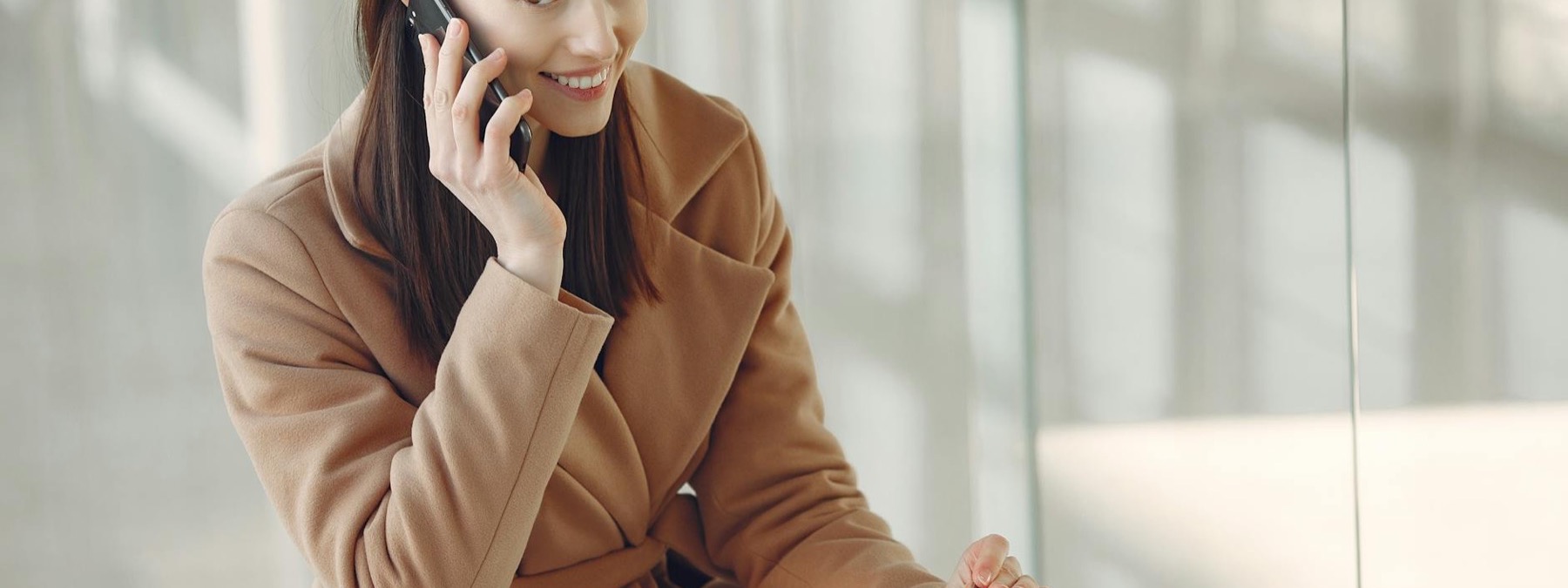 Smiling travel therapist using a phone and laptop for job alerts
